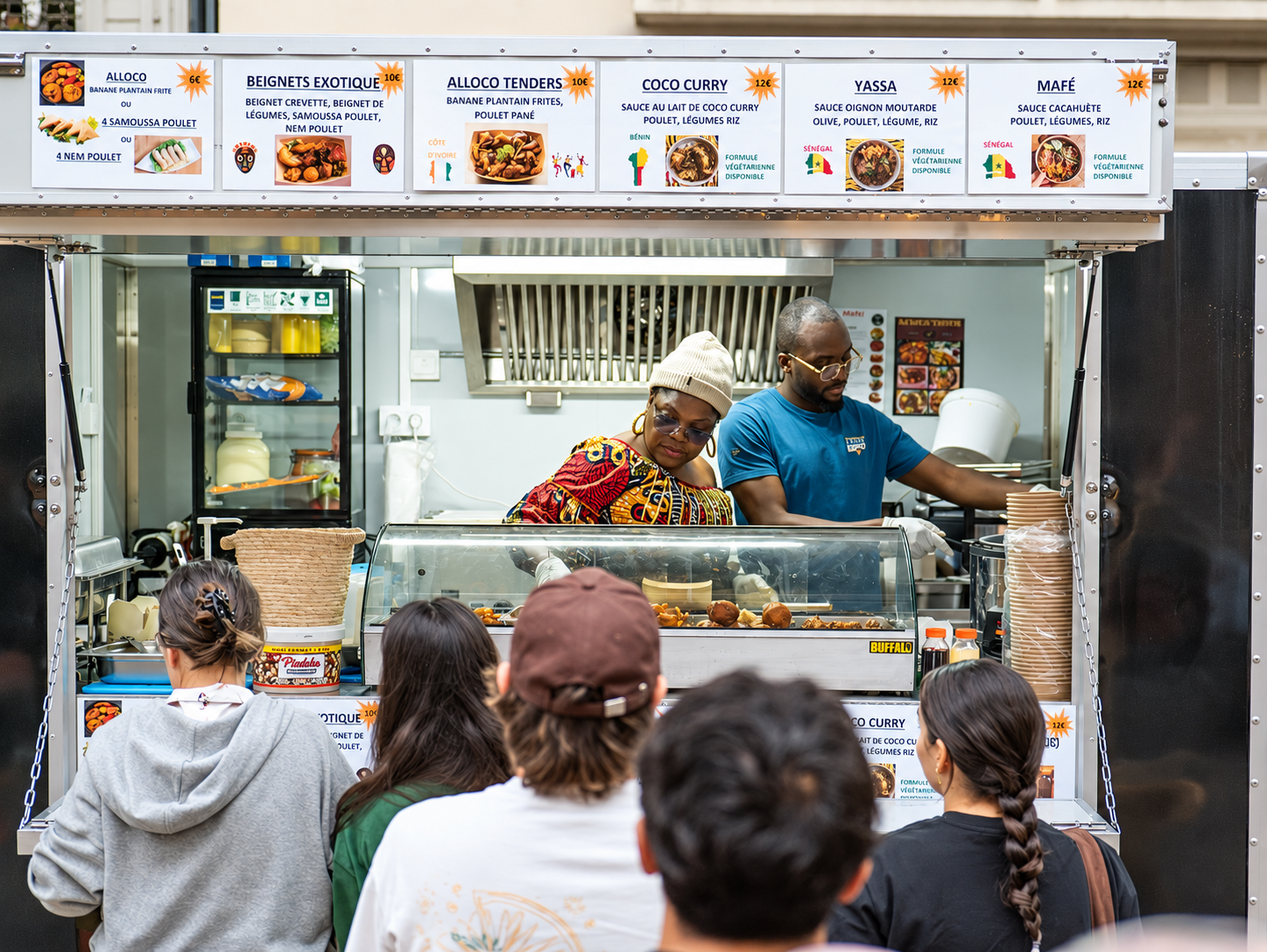 La maman et son fils au comptoir du food truck, clients en file d’attente